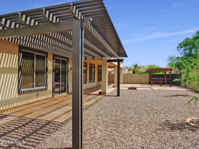 a view of a house with backyard and sitting area