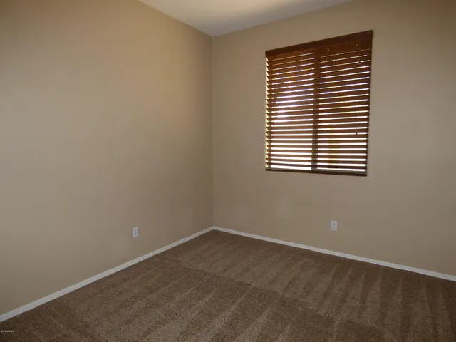 an empty room with a window and a ceiling fan