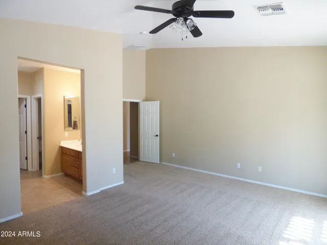 an empty room with a window and a fan