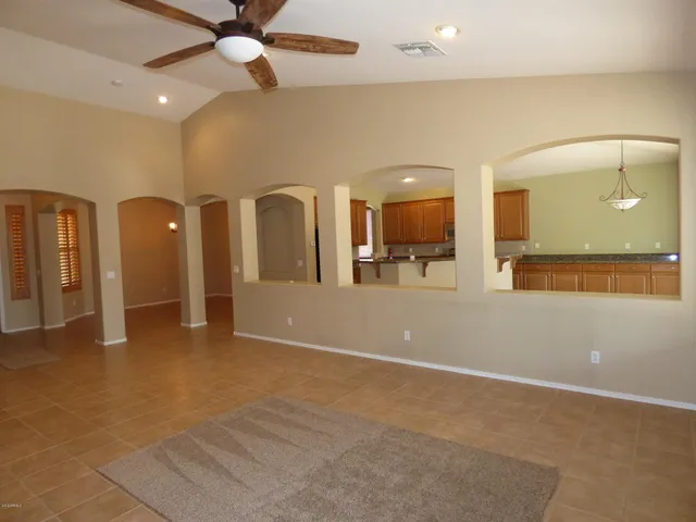 a kitchen with stainless steel appliances granite countertop a stove top oven a sink a refrigerator and white cabinets