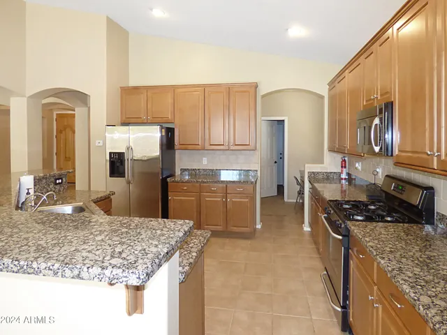 a kitchen with stainless steel appliances granite countertop a sink and a stove