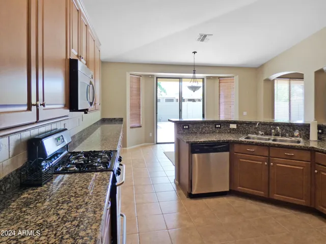a kitchen with granite countertop a sink and white cabinets