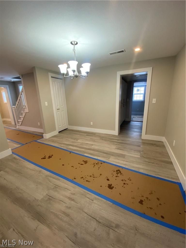 2803 State Road Vermilion, OH 44089 - Photo 22 of 28 Dining room with brand new chandelier, paintand light wood-type flooring.
