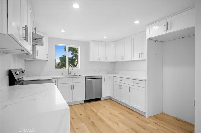 a kitchen with cabinets appliances a sink and a counter top space