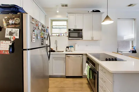 a kitchen with stainless steel appliances granite countertop a refrigerator a stove a sink and a microwave