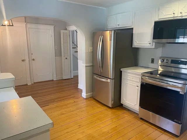 a kitchen with a refrigerator stove and wooden cabinets