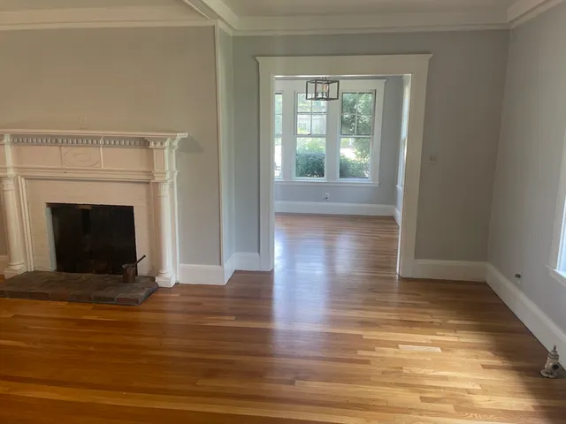 a view of empty room with wooden floor and fireplace
