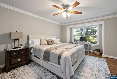 a bedroom with a bed a chandelier and a dresser