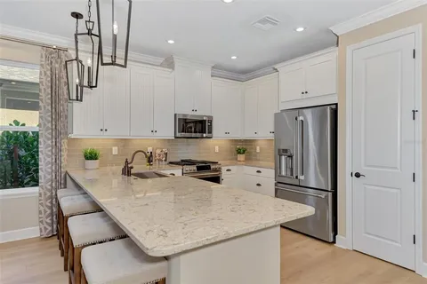 a kitchen with stainless steel appliances granite countertop a sink refrigerator and microwave
