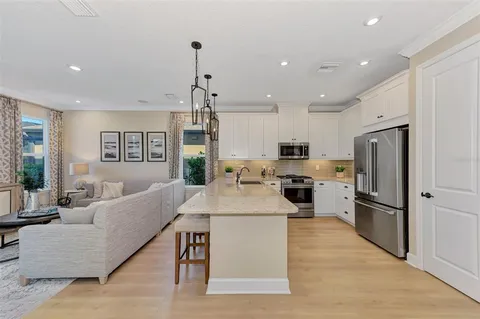 a large kitchen with kitchen island a large counter top stainless steel appliances and a center island
