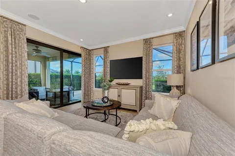 a living room with furniture kitchen view and a chandelier