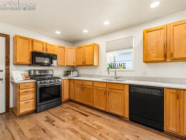 a kitchen with stainless steel appliances granite countertop a stove a sink and a microwave
