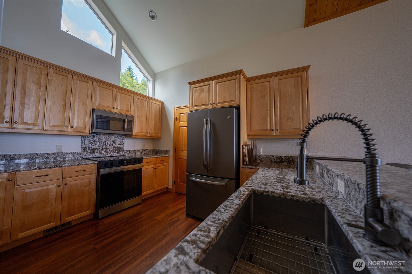212 Maletti Hill Road Port Angeles, WA 98362 - Photo 10 of 37 a kitchen with granite countertop a refrigerator stove and microwave