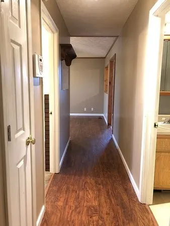 a view of a hallway with wooden floor and staircase