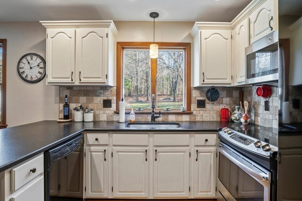 83 Thayer Road Monson, MA 01057 - Photo 13 of 42 a kitchen with stainless steel appliances granite countertop a sink a stove and a window