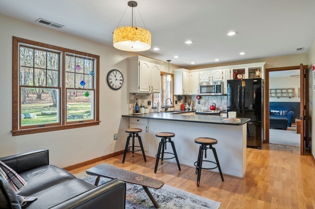 83 Thayer Road Monson, MA 01057 - Photo 16 of 42 a kitchen with stainless steel appliances granite countertop a stove a refrigerator a oven a sink with a dining table and chairs