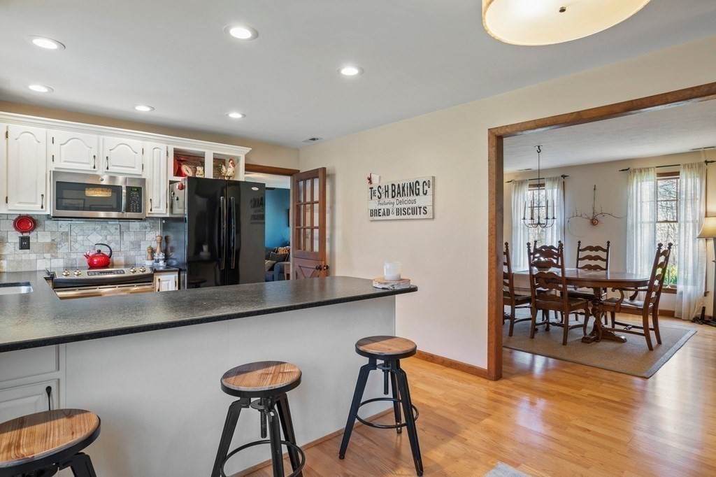 83 Thayer Road Monson, MA 01057 - Photo 23 of 42 a view of a kitchen with kitchen island stainless steel appliances wooden floor and chairs in it