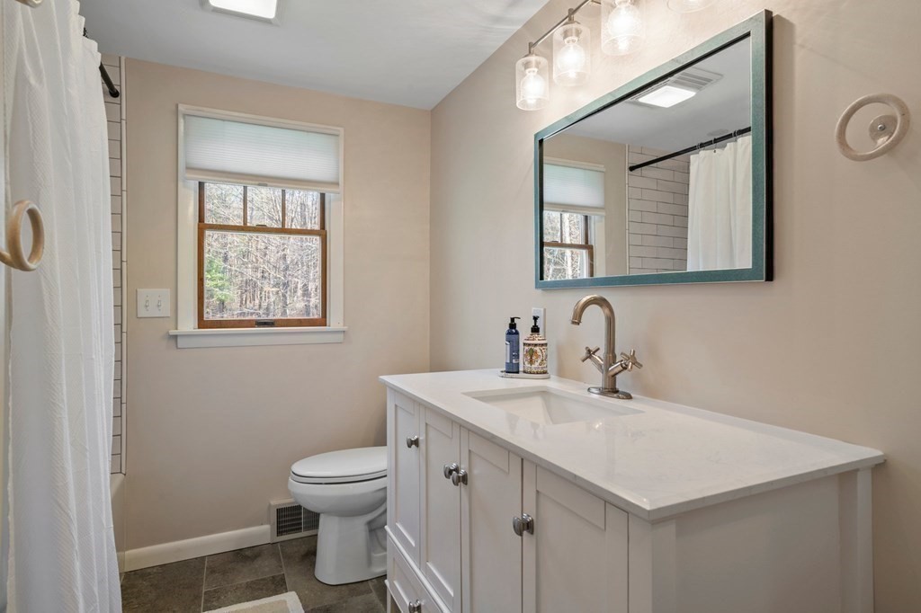 83 Thayer Road Monson, MA 01057 - Photo 33 of 42 a bathroom with a toilet a sink a mirror and a window