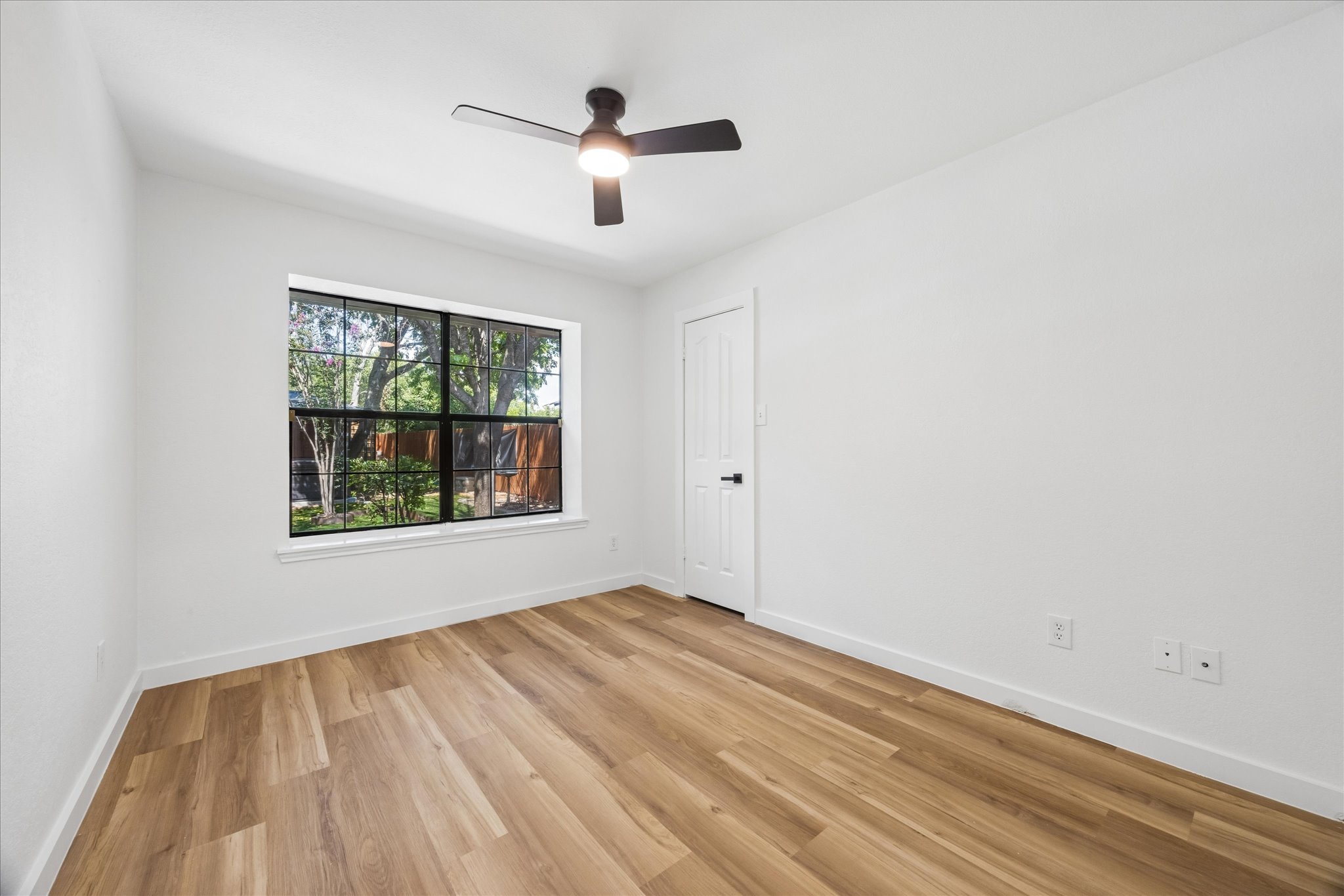 1706 Davis Street Taylor, TX 76574 - Photo 11 of 18 A well-lit bedroom features durable plank flooring and a functional ceiling fan for comfort.