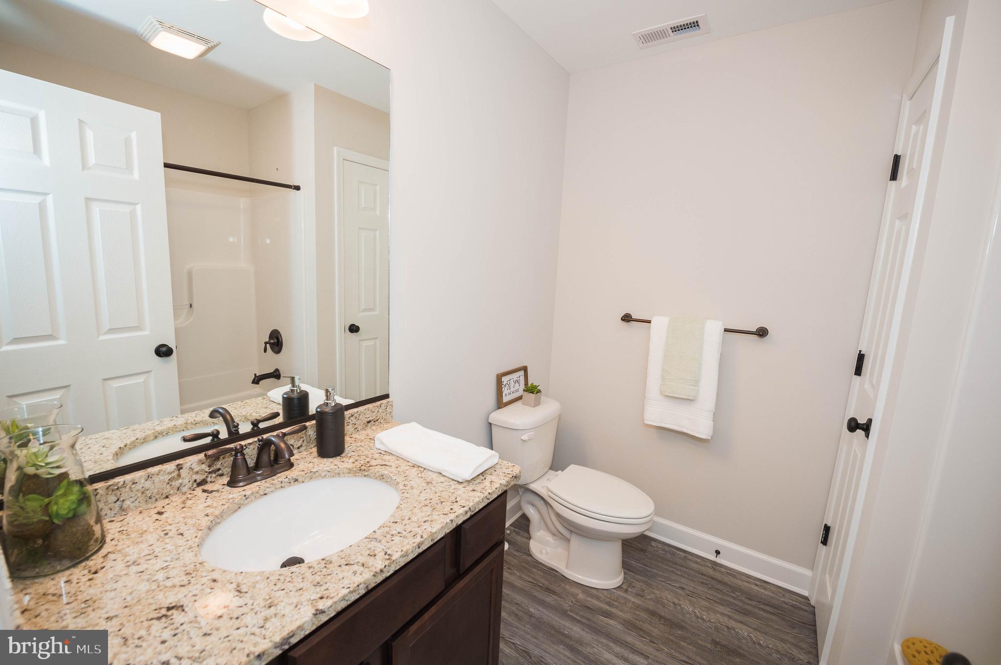 113 Morgan Run Snow Hill, MD 21863 - Photo 24 of 35 a bathroom with a granite countertop sink a toilet and a large mirror