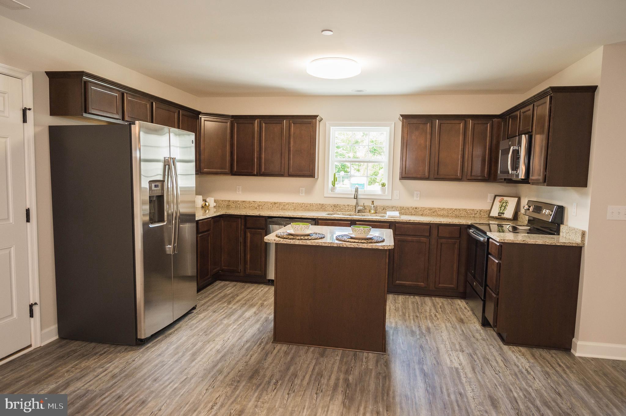 113 Morgan Run Snow Hill, MD 21863 - Photo 7 of 35 a kitchen with kitchen island granite countertop wooden floors stainless steel appliances a sink and a window