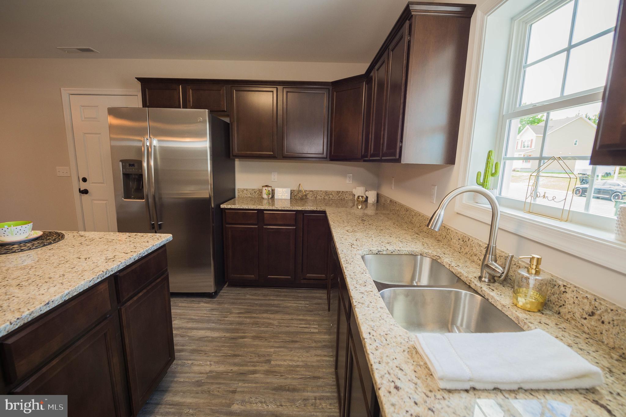 113 Morgan Run Snow Hill, MD 21863 - Photo 8 of 35 a kitchen with granite countertop a sink and a refrigerator