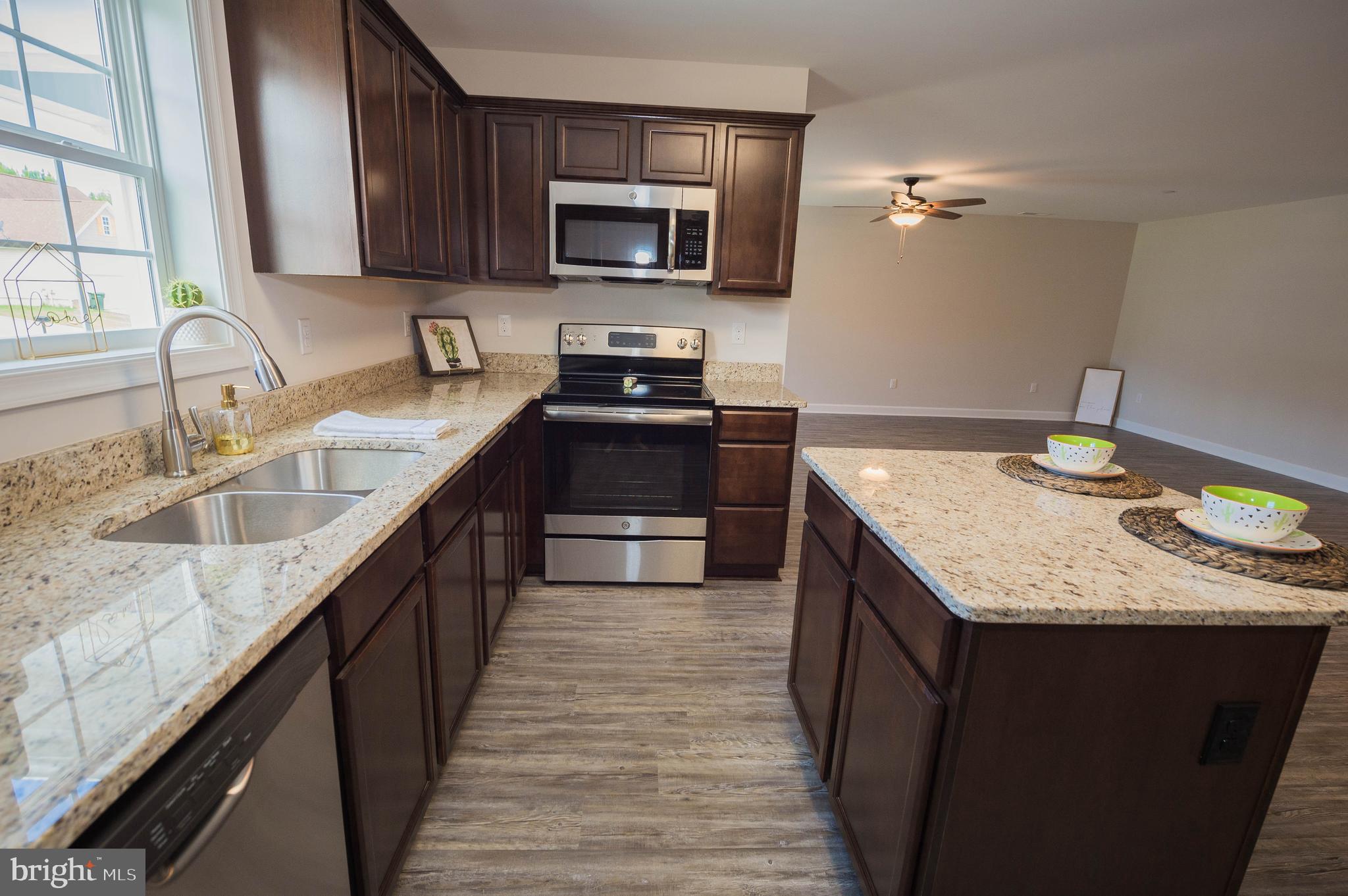 113 Morgan Run Snow Hill, MD 21863 - Photo 10 of 35 a kitchen with stainless steel appliances granite countertop a sink stove microwave and refrigerator