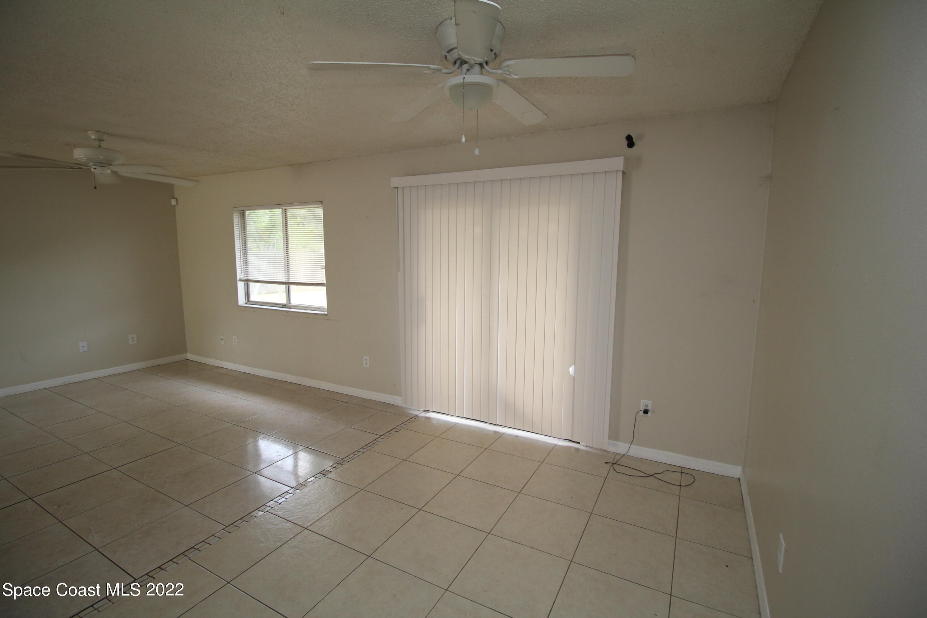 992 Sable Circle Southeast Palm Bay, FL 32909 - Photo 3 of 8 an empty room with windows and fan