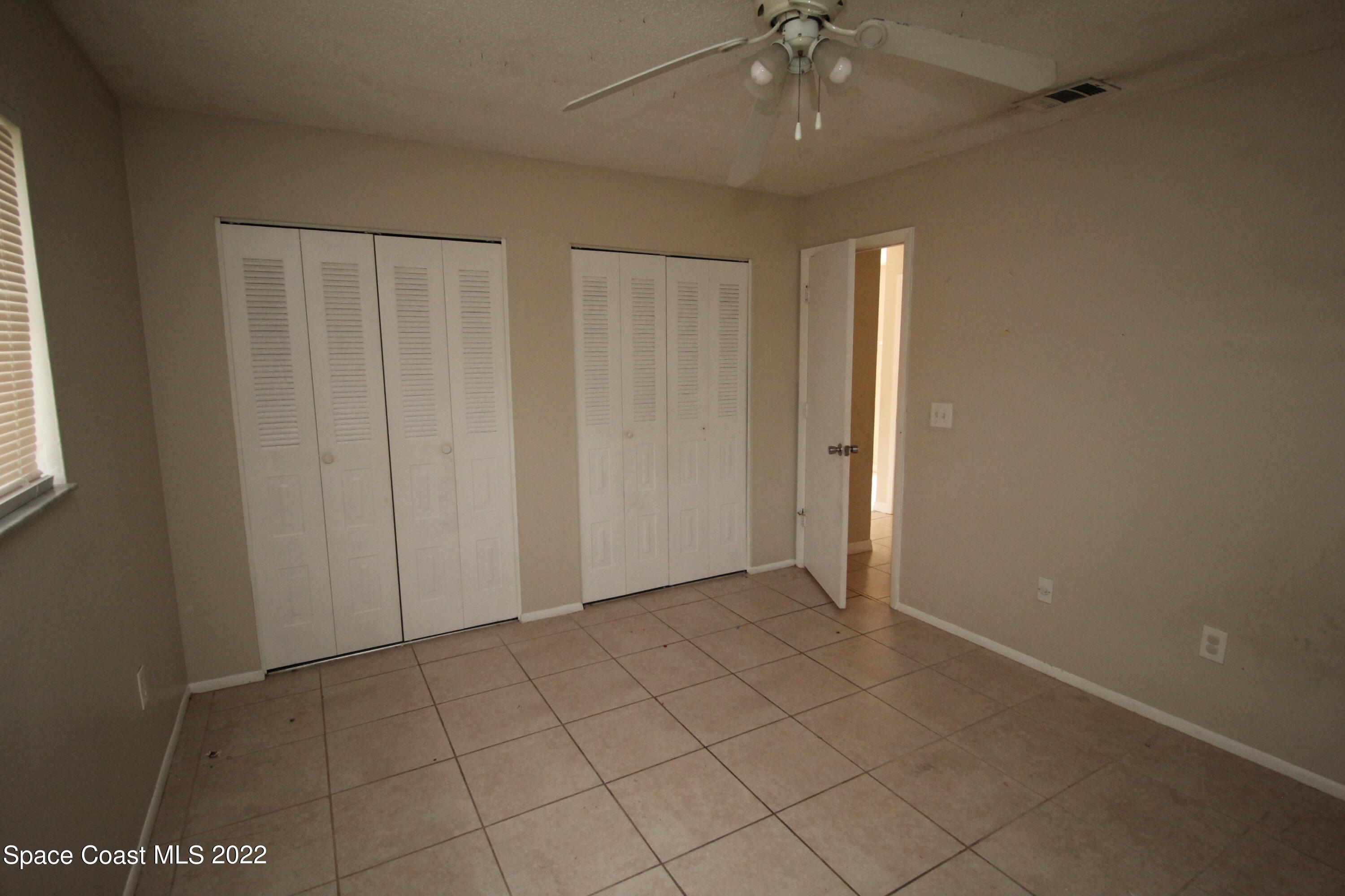 992 Sable Circle Southeast Palm Bay, FL 32909 - Photo 6 of 8 an empty room with chandelier fan