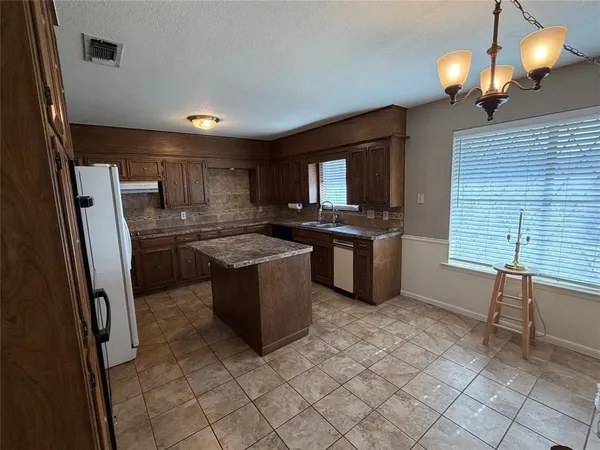 a kitchen with stainless steel appliances granite countertop a sink a stove a refrigerator and a window