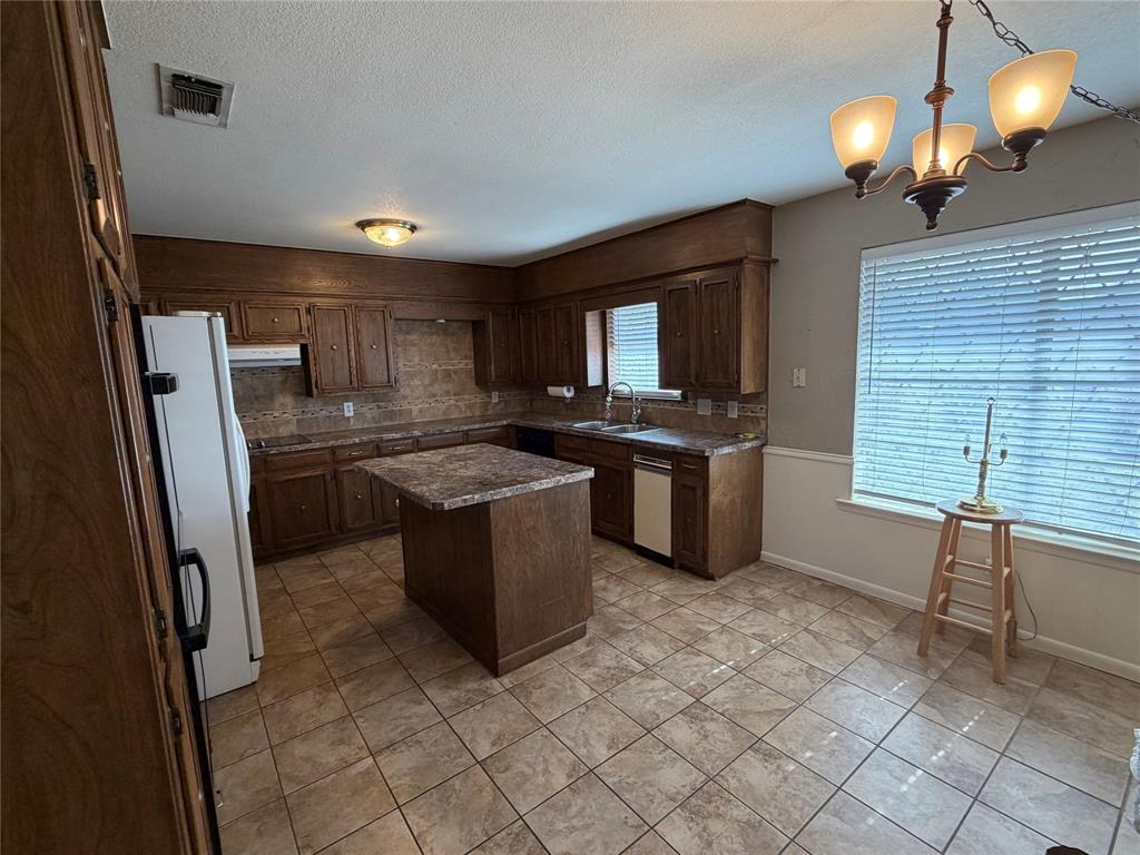 821 East Highway 199 Springtown, TX 76082 - Photo 7 of 26 a kitchen with stainless steel appliances granite countertop a sink a stove a refrigerator and a window