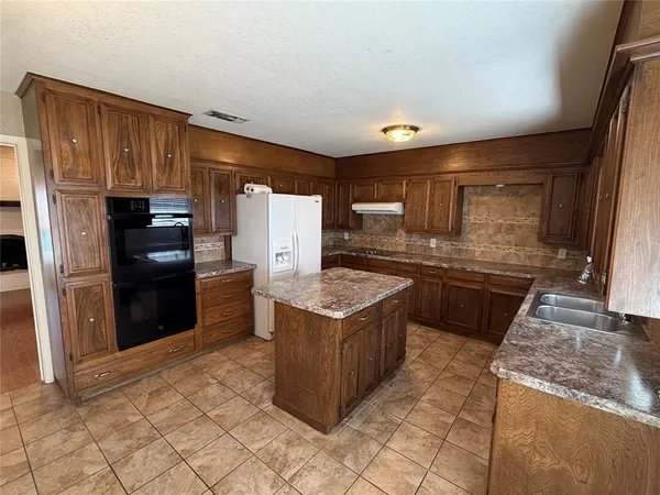 a kitchen with granite countertop a refrigerator and a stove