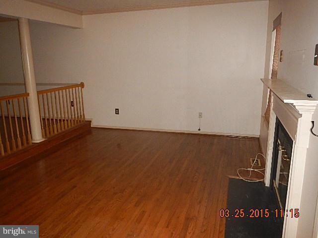 9324 Daly Court Laurel, MD 20723 - Photo 4 of 9 a view of an empty room with wooden floor and a fireplace