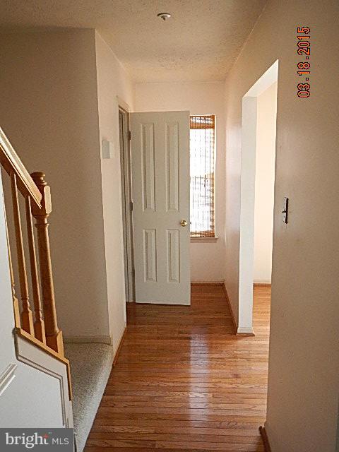 9324 Daly Court Laurel, MD 20723 - Photo 9 of 9 a view of a hallway with wooden floor and stairs