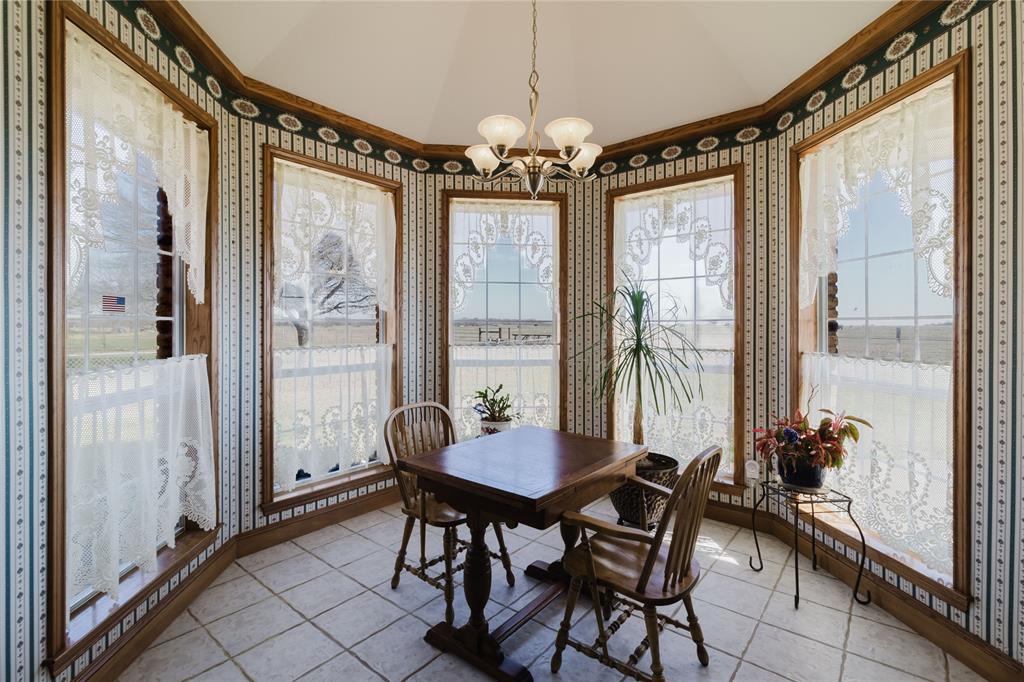130 Blazek Road Alma, TX 75119 - Photo 12 of 30 Dining space with light tile patterned flooring, vaulted ceiling, an inviting chandelier, and crown molding
