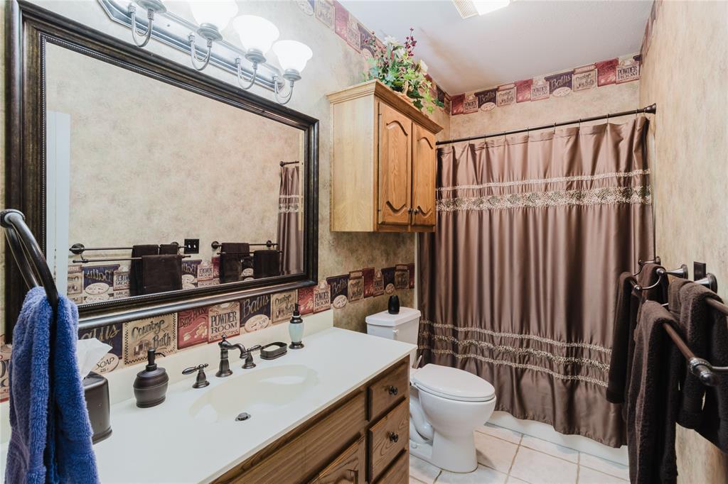 130 Blazek Road Alma, TX 75119 - Photo 28 of 30 Bathroom with tile patterned floors, vanity, toilet, and walk in shower