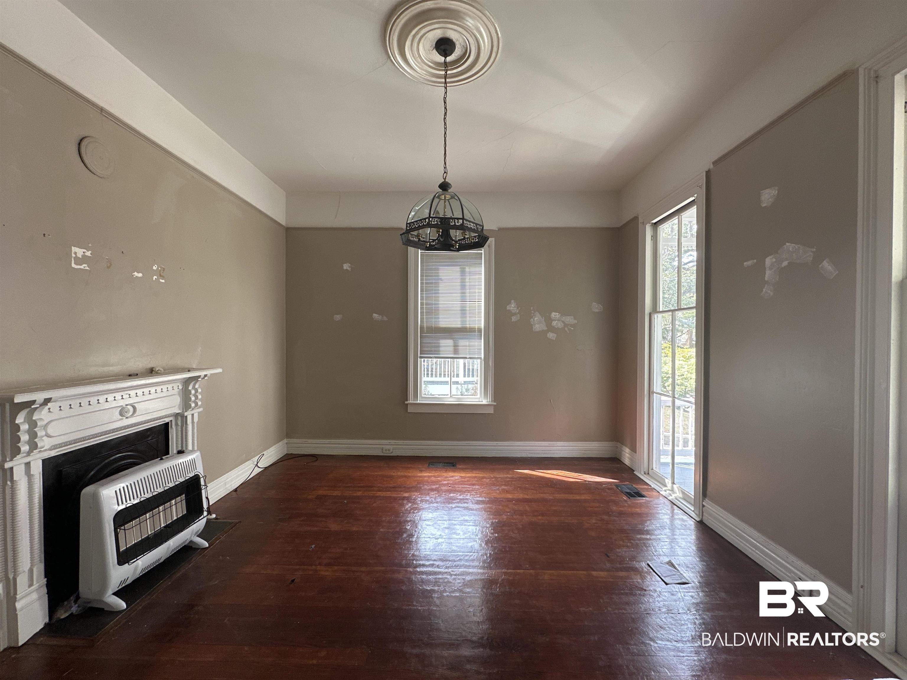 1119 Old Shell Road Mobile, AL 36604 - Photo 8 of 22 Unfurnished living room featuring a fireplace, dark hardwood / wood-style flooring, and heating unit