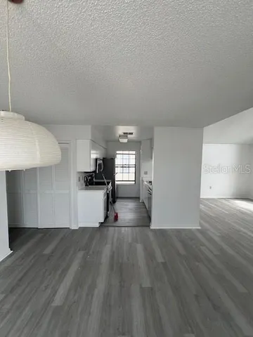 a view of empty room with wooden floor