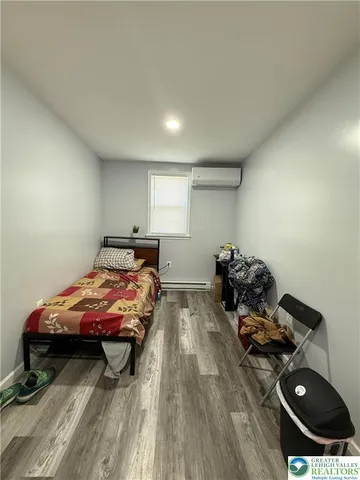 a bedroom with bed and a wooden floor