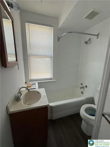 a bathroom with a sink toilet a mirror and shower