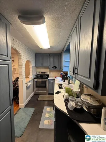 a kitchen with sink refrigerator and cabinets