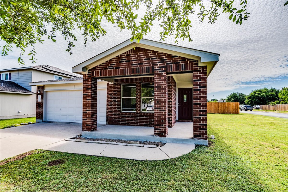 100 Easy Street Hutto, TX 78634 - Photo 3 of 36 A classic brick exterior with a welcoming porch and attached garage defines this charming dwelling.