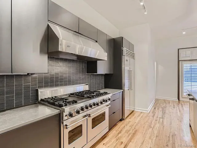 a kitchen with granite countertop a stove and a wooden floor