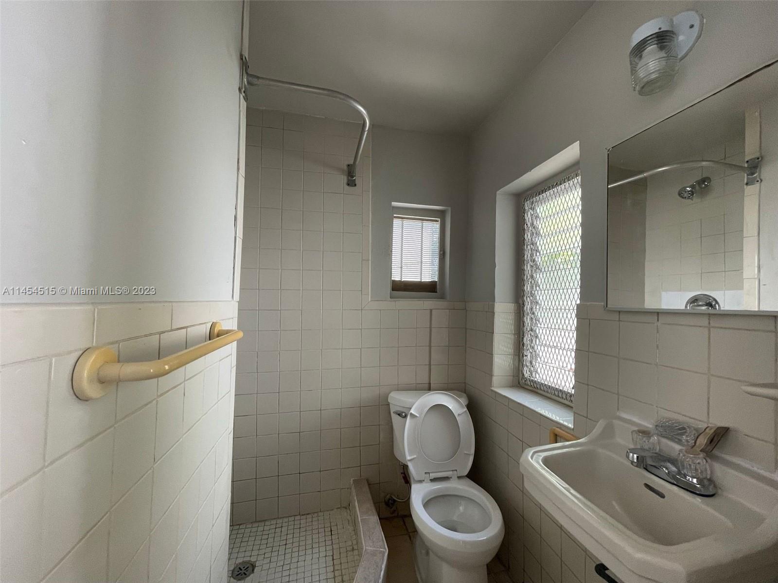6830 Harding Avenue, Unit 11 Miami Beach, FL 33141 - Photo 5 of 5 a bathroom with a toilet sink and mirror