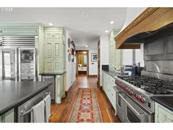 a large kitchen with stainless steel appliances granite countertop a stove and a refrigerator