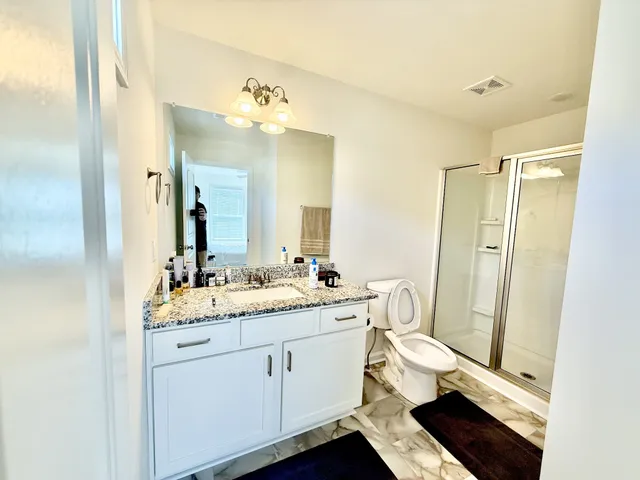 a bathroom with a double vanity sink toilet and shower