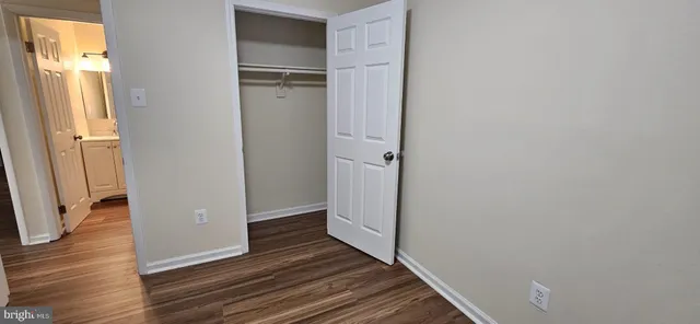 a view of a hallway with wooden floor and closet