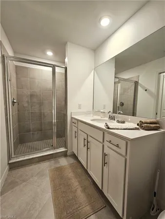 a bathroom with a shower sink and mirror