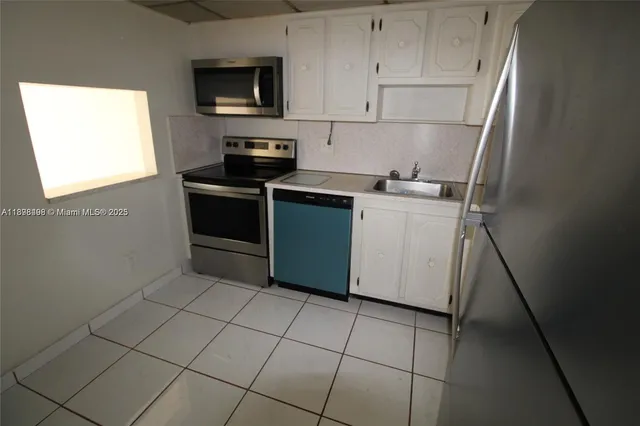 a kitchen with a sink a stove and cabinets