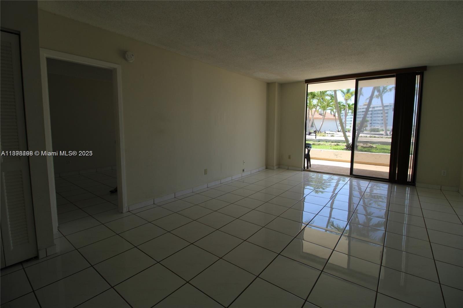 13499 Biscayne Boulevard, Unit 404 North Miami, FL 33181 - Photo 7 of 7 an empty room with wooden floor and windows